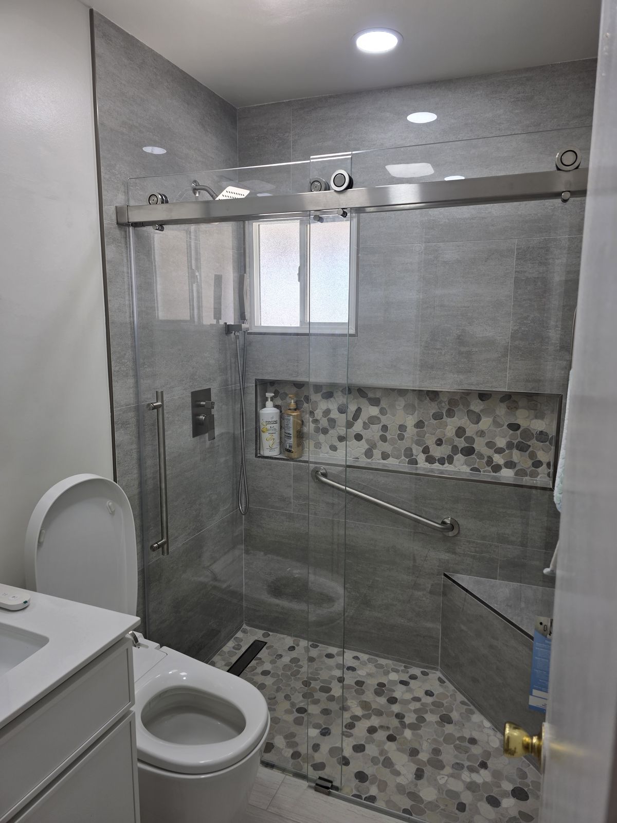 Walk-in shower with sliding glass door, pebble niche and linear drain, Buena Park