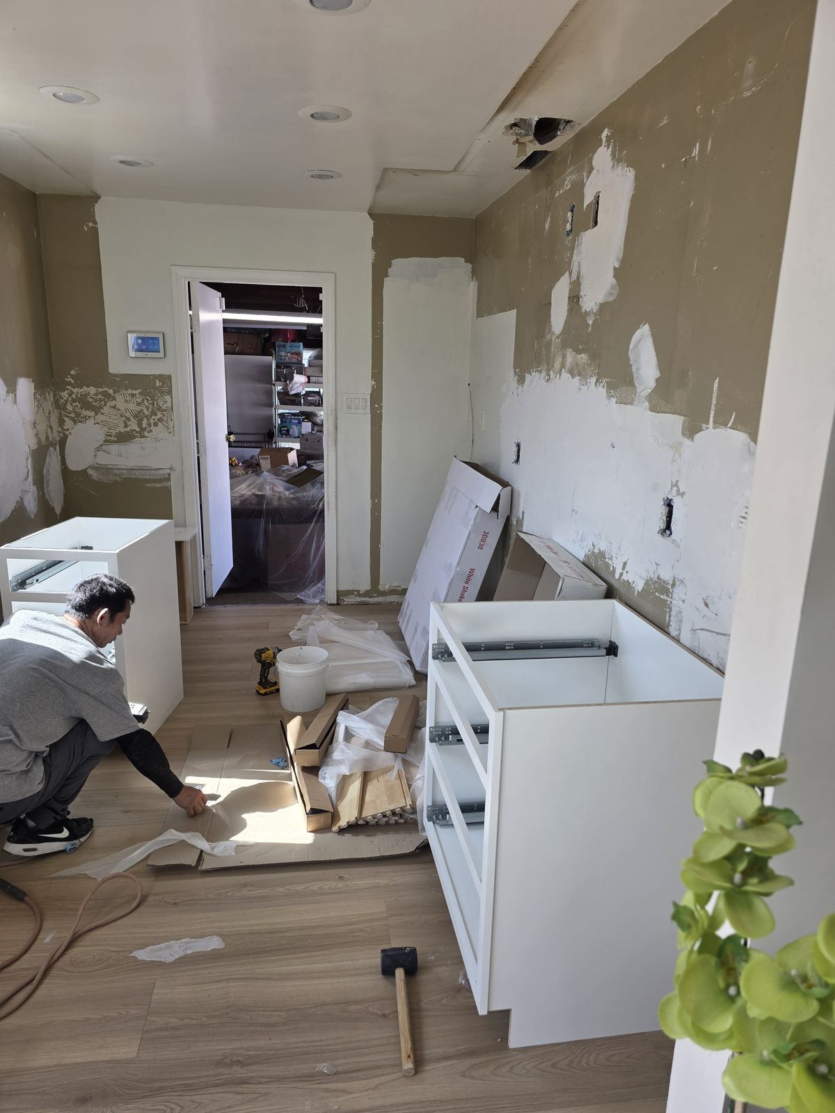 GiLand crew assembling kitchen cabinets on new flooring, Buena Park