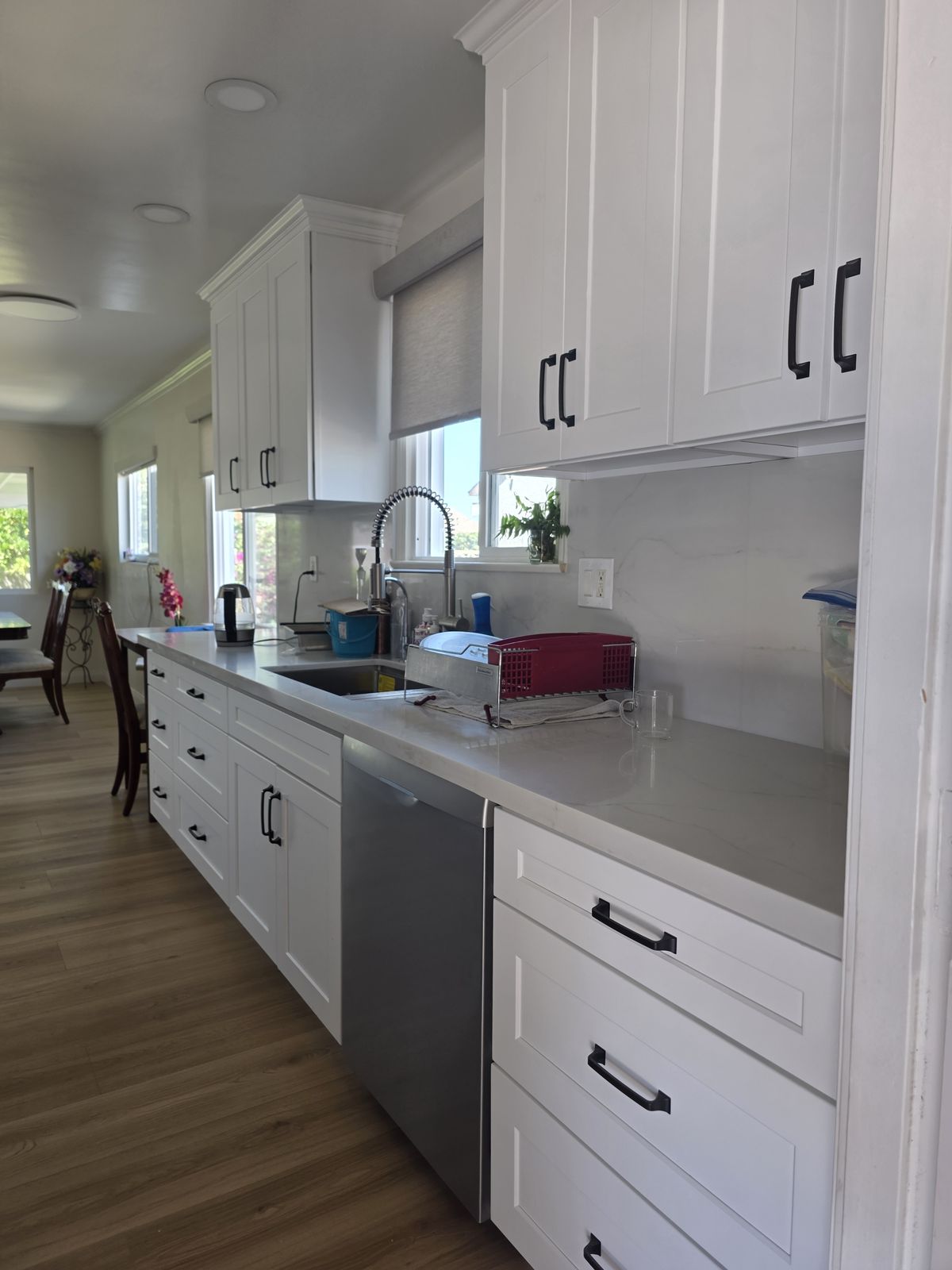 Completed galley kitchen with white cabinets and black hardware, Buena Park